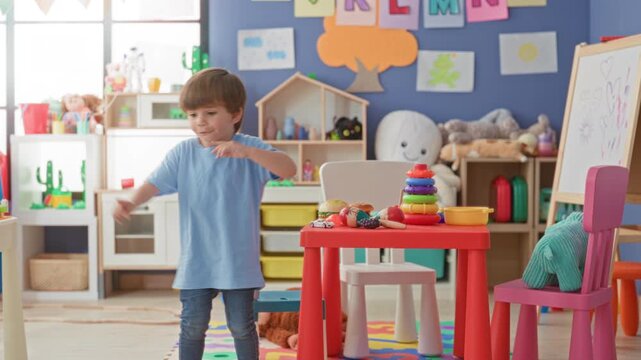 Little hispanic boy walking and smiling, reaches toward colorful stacking toy on table in preschool building; childhood play joy.