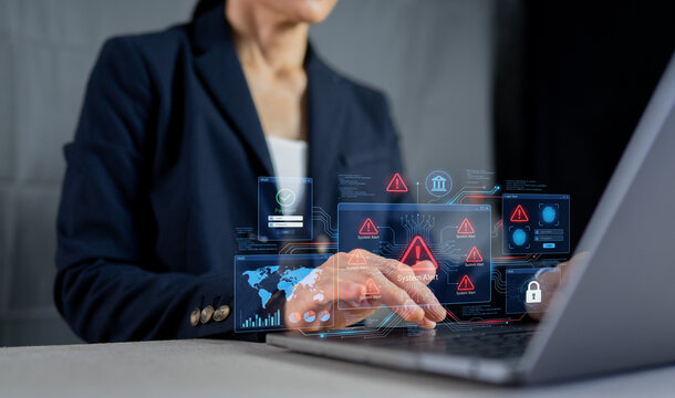 Businesswoman facing system alert warning on laptop, cyber attack threat and data security breach