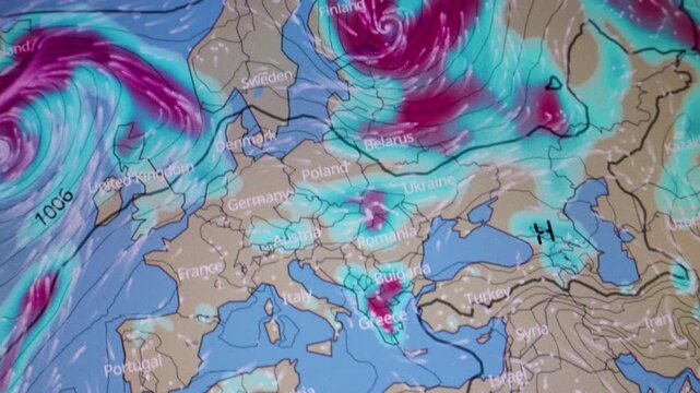 Severe weather display showing pressure lines thunderstorm zones and strong wind systems over Europe with colorful atmospheric data on a computer screen.