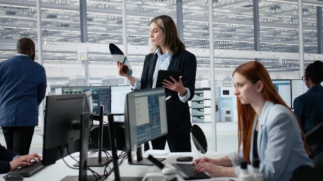 Portrait of smiling woman assessing substrates quality inside factory office, happy female engineer studying silicon wafer technology to improve electronics for semiconductor research.