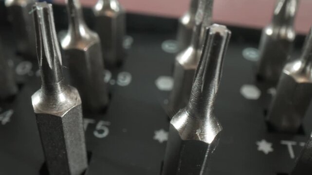 Close up camera panning across professional precision screwdriver bits set for small electronic device repair and maintenance.
