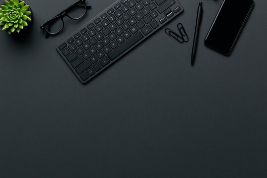 Workspace flat lay of a minimalist office desk with black keyboard and technology