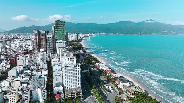 My Khe Beach, Da Nang, Vietnam &ndash; 4K aerial drone footage of tropical coastline, sandy beach, palm-lined coastline, ocean waves, and modern city skyline, costal roads, Son Tra Peninsula 