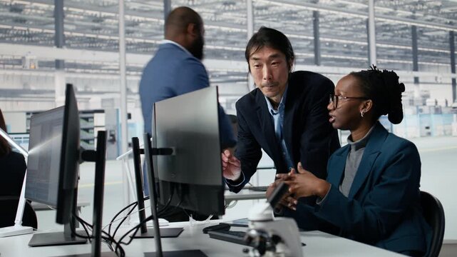 Senior manager and woman optimizing microchip production with AI in factory R&D workspace, improving semiconductor, AI and Asian team leader and worker in office for semiconductor research.