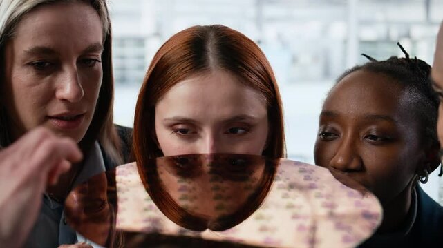 Diverse researchers examining silicon wafer close up in factory office trialing advanced materials, analyzing photolithography tech, semiconductor substrate and Teamwork colleagues.