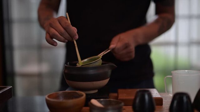 Chef preparing matcha tea using traditional tools