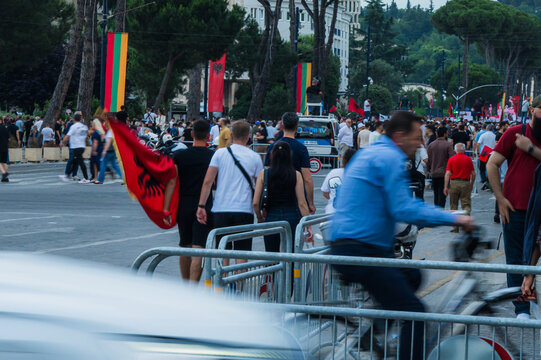 Tirane, Albania - 03 June 2026: View of a large crowd of protesters gathered on a city street with Albanian flags and metal security barriers during a public demonstration.