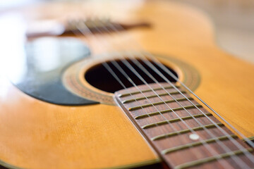 Obraz premium Close up of acoustic folk guitar strings and soundhole with wooden body