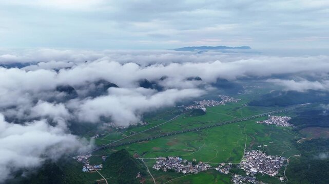  Karst Mountains with Sea of Clouds, Green Rice Paddies and Village Below, Aerial View