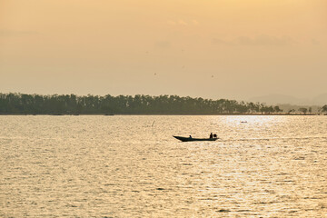 Fototapeta premium Small boat on a sea at sunset