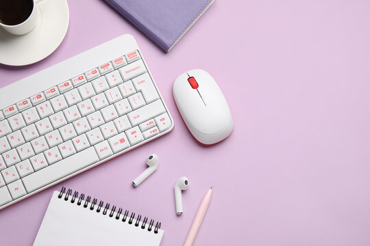 PC keyboard, mouse, earphones, coffee and stationery on lilac background