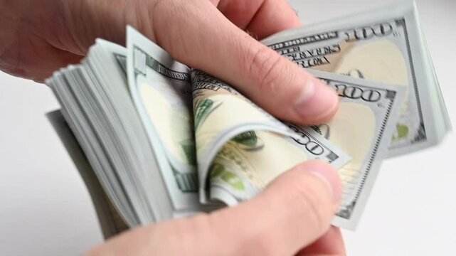 Hands counting stack of one hundred dollar bills in slow motion on white background cash close up.