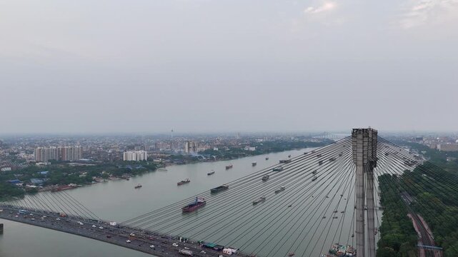 A spectacular aerial drone perspective of the majestic Vidyasagar Setu (Second Hooghly Bridge) in Kolkata, India, showcasing its intricate cable-stayed design spanning the river.