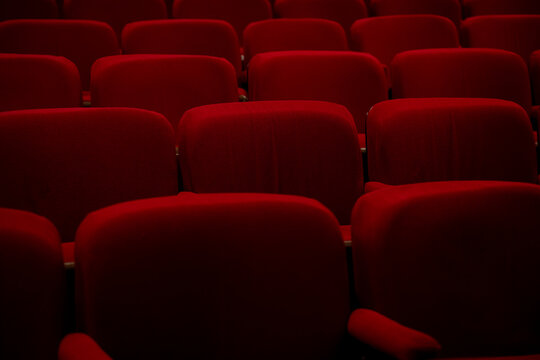 View of empty red theater seats in auditorium.