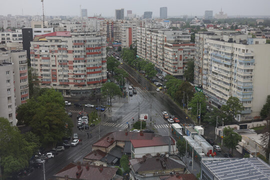 Overview of blocks of flats and traffic in Bucharest during a rainy late spring day.