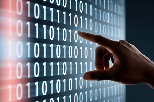 Hand touching glowing binary code on digital screen representing data, technology and cybersecurity interaction