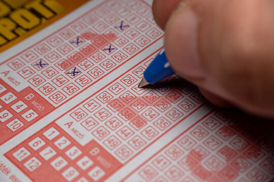 Filling Lottery Ticket Numbers with Pen Close Up