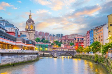 The historic Ribera Market and colorful waterfront buildings reflected in the Nervion River, Bilbao, Spain. © f11photo