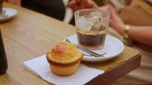 Caff&egrave; Leccese, prepared with espresso, ice and sweet almond syrup, is served beside a traditional Pasticciotto filled with custard cream in Lecce, Puglia, Italy, slow-motion lifestyle shot.