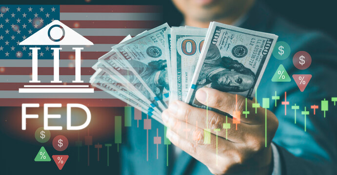 Businessman holding US dollar banknotes presenting FED rate hike and monetary policy concept. Global economics, inflation control, interest rates, and stock market volatility.