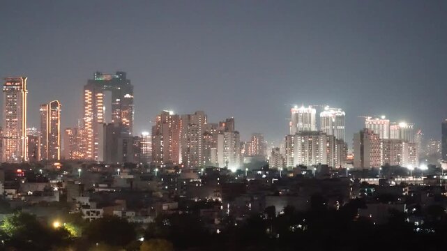 Aerial drone wide panning shot showing cityscape skyscrapers at night in mumbai hyderabad bangalore with smaller houses in foreground