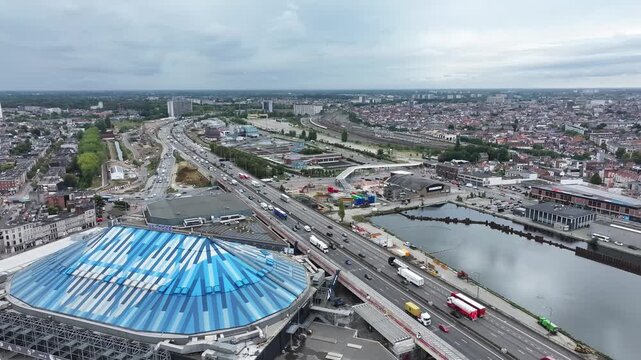 Rotating drone footage featuring the Antwerp Ring, AFAS Dome, Lotto Arena, and the city skyline, showcasing urban infrastructure and city life from above.