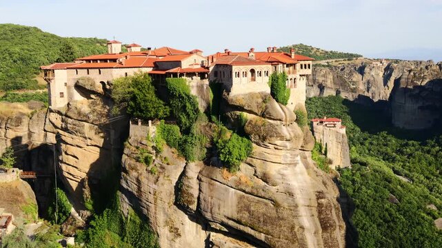 Spectacular landscape of Meteora featuring its world-famous monasteries perched atop towering sandstone rock pillars. Rising dramatically above the Thessalian plain in central Greece, the unique rock 