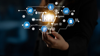 Obraz premium A hand holds a glowing light bulb symbolizing creativity, surrounded by icons related to business strategy, analytics, and innovation in a modern environment. Tessel