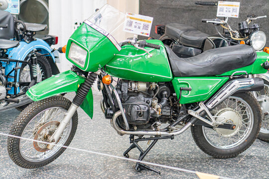 Vibrant green KMZ Dnipro antique motorcycle on display, off-road design, knobby tires, indoor setting with soft lighting, showroom or exhibition space, foreground fo - Kyiv, Ukraine - October 25, 2025