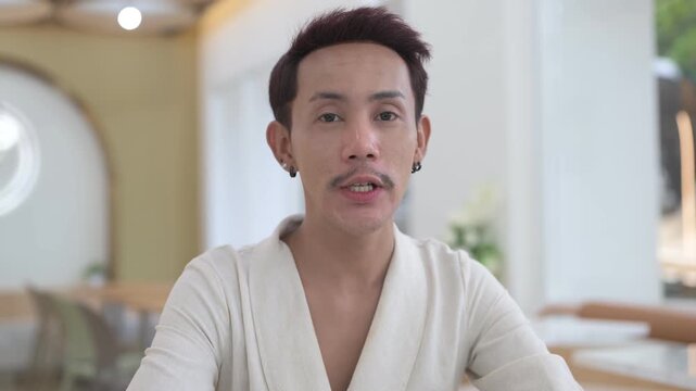 Thai Non-Binary Gay Man Talking to Camera for Coffee Shop Vlog Horizontal Shot