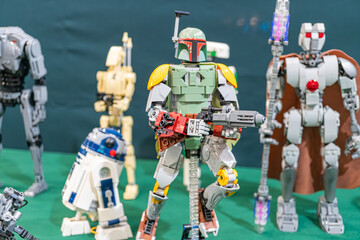 Naklejka premium Display case with Lego minifigures, arranged in a circle, representing characters from Star Wars franchise Boba Fett is the main figure in gray armor and helmet, wi - Kyiv, Ukraine - June 8, 2025