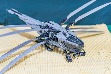 Naklejka premium Lego model of a dragon on Lego platform, dark gray and black dragon with light gray wings, beige platform, out of focus background, detailed craftsmanship - Kyiv, Ukraine - June 7, 2025