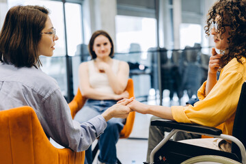 Obraz premium Diverse women holding hands providing support in discussion group