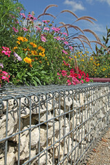 Fototapeta premium Gabion avec plantes fleuries dans un espace urbain