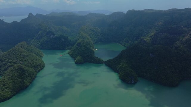 Sweeping 4K slow motion drone perspective of the Dayang Bunting Lake in Langkawi, showcasing the dense tropical foliage and the tranquil emerald lake surface.