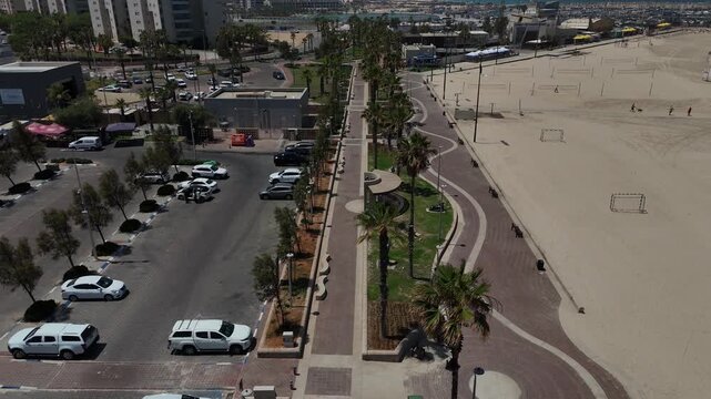 4K Drone Backward Reveal of HaKeshet Beach in Ashdod, Israel, Slow Motion Coastal Skyline, Mediterranean Sea and City View