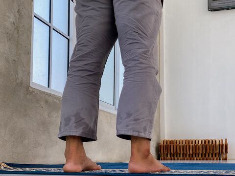 man standing on mosque carpet to pray