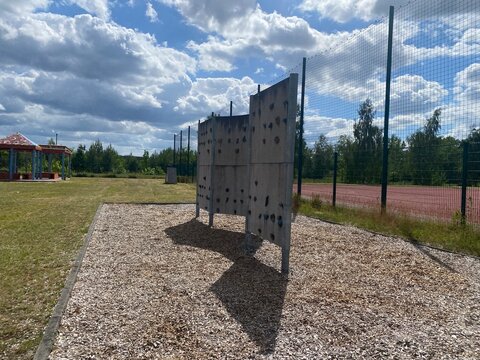Kletterwand auf einem Outdoor-Spielplatz unter blauem Himmel. Aktives Freizeitmotiv f&uuml;r Bewegung, Fitness, Kinder, Abenteuer, Motorik und sportliche Herausforderungen.
