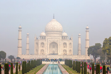 Obraz premium Beautiful front view of Taj Mahal mausoleum with the water fountain channel and crowds of tourists in Agra India Famous UNESCO world heritage site