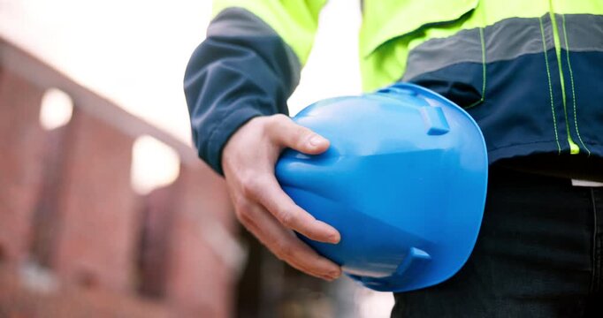 Man, hand and helmet at construction site for safety outdoor, renovation project or injury prevention. Person, PPE or hard hat by building for protection, infrastructure or civil engineering protocol