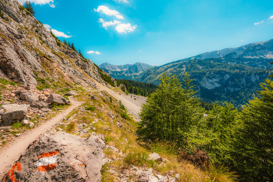 Alpine hiking trail from Prijevor in Bosnia to Trnovacko Lake in Montenegro, dramatic Dinaric Alps in Sutjeska park landscapes and crystal clear turquoise water.