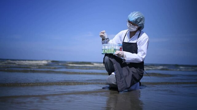 Scientist annalist wearing protective uniform, mask ,glove and under working water analysis effected from phytoplankton at sea analyst case in laboratory is environment pollution problem concept.