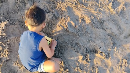 A kid playing toys in the sand beach © Agus