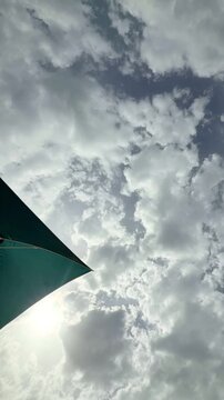 Sunlight through cloudy sky with green umbrella