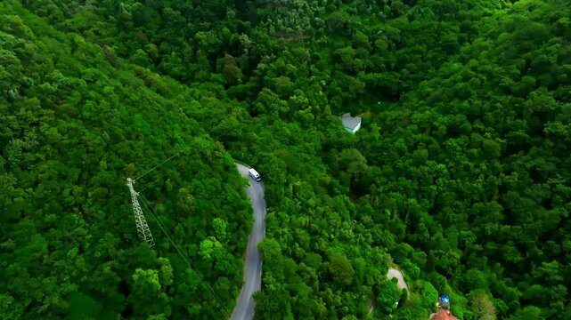 Drone shot around a motorhome stopped at a road in dense green hills of Rapallo