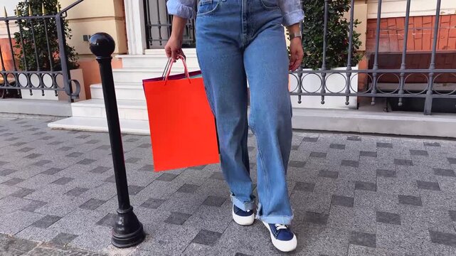 Happy woman walks down steps with bright shopping bags, showcasing recent purchases. Urban shopping and consumerism concept. Cheerful atmosphere highlights excitement of retail therapy