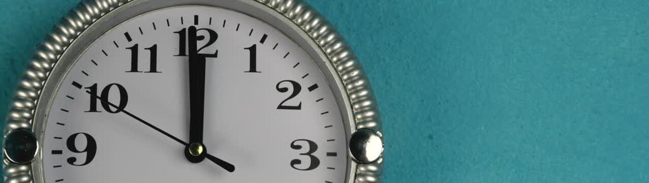 Clock face displaying a moment of critical timing The hour and minute hands point to twelve representing important schedules.
