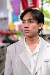 Obraz premium Portrait of non-binary Thai Isan person at street market sale