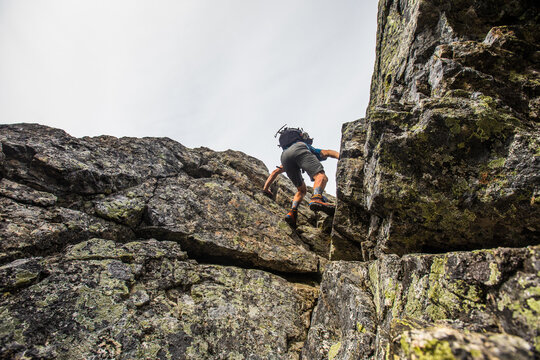 Man climbing up a steep rocky outcrop