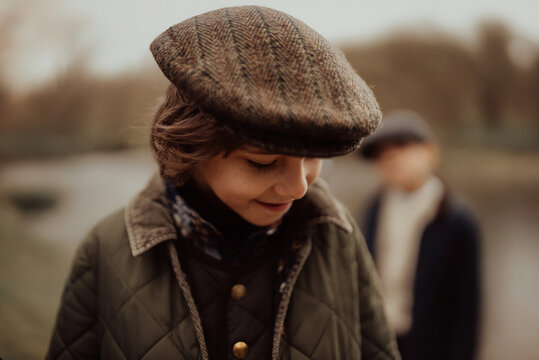 Boy Wearing Tweed Caps In Rustic English Countryside Setting